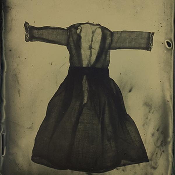 Dress_o_gram 9, photography by Susan Seubert. In these photogram tintypes by the 35-year-old Portlander, tiny delicate antique doll and children&rsquo;s clothes flare their lacy skirts and pucker their ruffles, the gowns and slips, bonnets and gloves wafting on their wavy-emulsion surfaces. The 25 mostly 20x16-inch dark- wood-framed girlhood garments hung on Froelick&rsquo;s walls like freshly washed laundry pinned on a line to dry, a gentle breeze blowing through their translucent forms. 
Says Seubert in her artist&rsquo;s statement, &ldquo;It was like magic when the image appeared on the plate&mdash;I was amazed at the beautiful and haunting quality of the surface combined with the shadow of an empty dress . . . The dresses appear to have an astonishing amount of volume; the open backs look sensual and feminine, but simultaneously empty and void of life. The distressed and runny emulsion makes them look old and adds a painterly quality to the surface of the print.&rdquo; 
	If you grew up in puffy-sleeved Polly Flinders dresses with Peter Pan collars or played with baby dolls, you may be immediately attracted to Seubert&rsquo;s &ldquo;Dress-O-Grams&rdquo; (her term, coined after Man Ray&rsquo;s Rayograms). Regardless, it&rsquo;s the eerily ethereal that captivates in these dark, grandma&rsquo;s-attic artifacts conjuring up the creepy. 
	It begins with the series&rsquo; title, which translates as &ldquo;Remember thy mortality,&rdquo; and shares its name with that of the postmortem photography popular in 19th-century America and Europe. After seeing her first, finished Dress-O-Gram, Seubert was reminded of the Victorian-era memento mori daguerreotypes (later replaced by ambrotypes, tintypes and carte-de visite), many of which were of babies and toddlers during a time of high childhood mortality. Vacant of the dolls and children that once wore them, the garments in her photogram tintypes are ghosts of their former selves, roaming a nebulous realm like displaced souls in transition to the Afterlife. 
Indeed, Seubert&rsquo;s spectral images exude an aura of innocence and loss, nostalgia and death, as do their 19th-century counterparts. (Hers, too, are portraits, in effect, if not still lifes.) Then, people lingered lovingly with their photos of the deceased, which served as reminders of the inevitability of death, recognition of the individual&rsquo;s passing and remembrance of their life. The portraits, helping loved ones mourn, were often displayed with those of the living in family albums. 
There are other ways that Seubert&rsquo;s Memento Mori photogram tintypes parallel the postmortem photographs of the 19th century (not that she intended any of this, but here goes). The occupants of the antique attire she purchased on eBay are not known to her. Similarly, many newborns of the 19th century weren&rsquo;t named until their survival was assumed, as was the practice during a time when children weren&rsquo;t necessarily expected to live beyond a year. Those who didn&rsquo;t were listed as &ldquo;unnamed&rdquo; or &ldquo;anonymous,&rdquo; often with little more than the photographs of their corpses as the remaining evidence of their lives. 
In many of those postmortem photos of, particularly, children, flowers filled the frame, to such an extent that they often nearly obscured the body, while their comforting presence eased viewers&rsquo; access to it. The dresses and other apparel in Seubert&rsquo;s series, themselves as beautiful as flowers with their lacy and textural intricacies enhanced by the photogram&rsquo;s penchant for capturing such details, entice the viewer into the morbidity of the image&mdash;the mere skeleton of a precious life&mdash;expressed by the precision of the garments juxtaposed with the murky nature of the emulsion process.
Take it a bit further and you can&rsquo;t help but see hints of sexuality in Seubert&rsquo;s Memento Mori series. There they are in the unfastened state of the dresses (she removed snaps and buttons to avoid glaring black dots), and doll bra and panty set and corset. She already attributes the &ldquo;sensual and feminine&rdquo; to this body of work, but she hadn&rsquo;t considered how the understated sexuality in her images echoes the covert expression of it in Western art of the 19th century. Then, sex was repressed in society as much as death was freely and openly discussed, and photographed.
Seubert&rsquo;s photograms carry forward the tradition of the medium (made by light exposed directly onto an object placed on a light-sensitive film or other surface), from the first ones ever created, in the late 1830s by William Henry Fox Talbot (who called them photogenic drawings). Invented by Hamilton Smith in 1856, the traditional tintype, also called a ferrotype, was never made with tin, but a thin sheet of black japanned iron, &ldquo;coated with asphalt, then sensitized to light with salted collodion or a gelatin emulsion of silver salts. Slightly underexposed, the image shows up after developing as a positive against its own black background,&rdquo; explains photography historian and writer Lyle Rexer in his book, Photography&rsquo;s Antiquarian Avant-Garde: The New Wave in Old Processes (Harry N. Abrams, Inc., 2002). Seubert&rsquo;s dryplate versions, of anodized aluminum sheets coated with silver gelatin emulsion, achieve the resultant optical illusion characteristic of all tintypes, due to the metal&rsquo;s dark surface. But because her images are photograms, the mostly white wardrobe looks black, like negatives.
She joins other contemporary photographers in adopting 19th- and early-20th-century processes in a &ldquo;movement&rdquo; that Rexer calls the &ldquo;antiquarian avant-garde.&rdquo; Again, he says in his book, &ldquo;Although the past informs this work, it is the present that incites it,&rdquo; pointing to anything from photographic processes and equipment to subject matter to rebellion against the digital. Within the last decade or so, there&rsquo;s Jerry Spagnoli&rsquo;s daguerreotypes (images on silver-plated copper); Stephen Berkman&rsquo;s, Mark Osterman&rsquo;s and Jody Ake&rsquo;s ambrotypes (an underexposed collodion-on-glass image developed in iron sulfate and fixed in cyanide); Christine Schiavo&rsquo;s and Deborah Luster&rsquo;s tintypes; and Dan Estabrook&rsquo;s emulsion-on-steel photographs&mdash;to name a mere few. When it comes to 20th-century photograms, Seubert is hardly alone, from Ray&rsquo;s and Laszlo Moholy-Nagy&rsquo;s, early in the last century, to recently produced works by Adam Fuss and Jayne Hinds Bidaut.
Get to Bidaut&rsquo;s photogram tintypes and you see an uncanny resemblance to those by Seubert, who maintains she was unfamiliar with her work while producing Memento Mori. The theme of mortality thrives in the former&rsquo;s tintypes of collected dead insects. These and Seubert&rsquo;s photos present themselves the way science was visually recorded by imagists in the photography of the 19th century, &ldquo;the time of inventory and catalogue, of classification and objectification,&rdquo; continues Rexer. &ldquo;Many of the artists using old processes today focus on such inventories as emblems of modern scientific consciousness.&rdquo; That said, Seubert&rsquo;s Dress-O-Grams begin to look more and more like medical X-rays or laboratory specimens.
 Again, Rexer: &ldquo;Perhaps the most pervasive legacy of nineteenth-century imagery is anatomical. Body parts, fragments, and skeletons show up in the developing trays of contemporary artists with alarming frequency . . .&rdquo; It&rsquo;s Bidaut&rsquo;s &ldquo;Human Skeleton&rdquo; (1999), a dryplate photogram tintype made with 12 plates, and especially her four-photogram tintype, &ldquo;Chrysemys Scripta Elegans (Turtle Skeleton)&rdquo; (1999), that cinch the similarity between the two artists. The reptile&rsquo;s bony form mimics Seubert&rsquo;s &ldquo;Christening Dress&rdquo; (2005), both images with their arms stretched out, centered on a four-square field of drippy, unevenly applied emulsion. 
Two of Seubert&rsquo;s Memento Mori dresses make their debut in her 2003-2004 series, Pretty Things. Also tintypes, they previsualize the succeeding series, with the apparel&rsquo;s centered placement on the irregularly coated surfaces of their anodized aluminum. The small tintypes of Masao Yamamoto inspired Seubert to create her intimate 2x2-inch photographs of these garments, fruits, flowers and snow scenes.
The loveliness of these objects, however, stands out as an aberration in her oeuvre, preoccupied as it is with subject matters related the darkest corners of human nature&mdash;from domestic violence and dump sites of murder victims to madness and remembrance of the dead. Seubert&rsquo;s very first four series&mdash;beginning with her first solo exhibition in 1992 (at the city&rsquo;s now-defunct Jamison Thomas Gallery), upon graduation with a BFA in photography from Portland&rsquo;s Pacific Northwest College of Art&mdash;present abstract, social-documentary-infused images that toy with the ironic and include text. 
She jumps right in with rape, in Every Three Seconds (1992), named for how often a woman is raped in the United States. In one of the 40x60- and 70x90-inch gelatin silver and color photomurals, titled &ldquo;It Ain&rsquo;t Natural,&rdquo; a man&rsquo;s hand clutches his own crotch, with the words, &ldquo;It ain&rsquo;t natural for a man to go without.&rdquo; This series segues into Violence Objects (1994), where Seubert introduces us to her tendency to catalogue. In her 4x5-inch platinum prints, 30 household objects (individually poised against black cloth backgrounds) stand in for weapons used against women. The photographs are accompanied by text taken straight from public-domain domestic violence reports. 
Panphobia (1995) comes next, in response to Seubert&rsquo;s self-inquiry regarding her interest in others&rsquo; savagery. Continuing the format from her previous series, again she studio-shot 30 isolated objects, each one representing things feared, such as a knife (aichmophobia, fear of sharp objects) and a seascape (thalassophobia, fear of waves). She photographed the phobias&rsquo; technical names (in the script of antique maps) as negatives, and printed them below their corresponding image in these contact-printed platinum prints.
As portraits, still lifes and catalogued items, the photographs in these last two series foreshadow Seubert&rsquo;s moody treatment of her antique garments to come, taking the gloomy route that nearly all of her works traverse. But nothing gets more macabre than The Ten Most Popular Places to Dump a Body in the Columbia River Gorge (1998). Like the perfect con artist reveling in his ruse, the 16x20-inch selenium-toned, gelatin silver prints pose as pretty landscape photos&mdash;until you get to the fine print, excerpts from sheriff-department investigative reports. (Seubert shot these banal body-dump sites in the spirit of turn-of-the-last-century landscape photography, with an 8x10 view camera and Ansel Adams&rsquo; Zone System.)
In Chimeras (2000), these first tintypes of hers explore illusions and fabrications of the mind. Here, film noire-like narratives summon a sense of danger&mdash;or at least of dreams, where many of the series&rsquo; scenes originated for Seubert. After her Sextablos series (2001)&mdash;a tintype inventory of sex toys she found disturbing (part of a group show entitled, &ldquo;Sextablos: Works on Metal,&rdquo; organized by Chicago-based artist, Michael Hernandez De Luna)&mdash;Seubert continues with additional nods to the 19th century. Neurasthenia (2003) seizes the absurdities of insanity with an allusion to the Victorian-era nervous disorder brought on by stresses accompanying the rise of modern industrial society. Named after this psychopathological condition, Seubert&rsquo;s series was inspired by her emotional response to the tragic events of September 11th. Some of the images in these abstract figurative tintypes&mdash;a tensely furrowed brow, a man&rsquo;s head in midshake&mdash;call up the ambrotypes of Stephen Berkman&rsquo;s &ldquo;Untitled&rdquo; (2000) and Ake&rsquo;s &ldquo;Self-portrait in Four&rdquo; (1998).
Seubert&rsquo;s fascination with the doomed and the dismal finds its roots in her six months at Magnum (the year she graduated) where she assisted Susan Meisalas and met other Magnum greats, her long-time interest in photojournalism (with only a fleeting desire to pursue it as a profession), the edgy art she experienced there in New York and, of course, her childhood. Domestic disputes, child abuse, theft and racial tension were common in the central-Indianapolis neighborhood where Seubert was raised, by loving parents. Maybe it&rsquo;s this contrast that would later shape her work, epitomized by the tension of opposing elements, visually and conceptually. 
In Memento Mori, the dichotomy hinges itself on melancholy and enchantment, lending a quality that is as undeniably romantic as the 19th-century memento mori photographs were sentimental. Seubert&rsquo;s thoughtful and skillful approach towards photographic processes of previous centuries coupled with the brooding nostalgia of her subject matter&mdash;inviting our own myths and memories, recollections and reveries&mdash;transports the past into the present, and transforms them into an era of her own. 
By Claire Sykes. Tintype, enlarger, darkroom. Dry plate tintype. In Object, Clothing. Dress_o_gram 9, photography by Susan Seubert. Image #22213