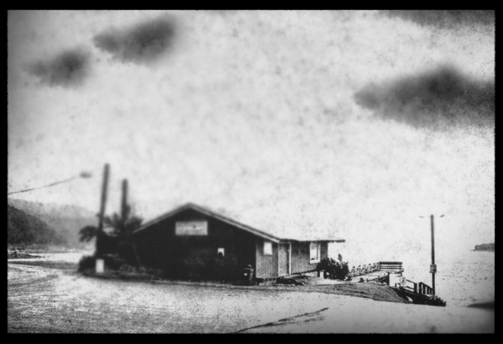 Port Waikato, photography by Naomi Williams. Part of a series work created using both digital and analogue techniques; the final output is a series of unique silver gelatin prints that operate to explore the way in which we view both, the land and the photograph. The creation process adds areas of limited focus and changes the image from its original form enabling the viewer to re-imagine the space, allowing the landscape to be both familiar and indistinct.. Digital Negatives. In Construction, Place